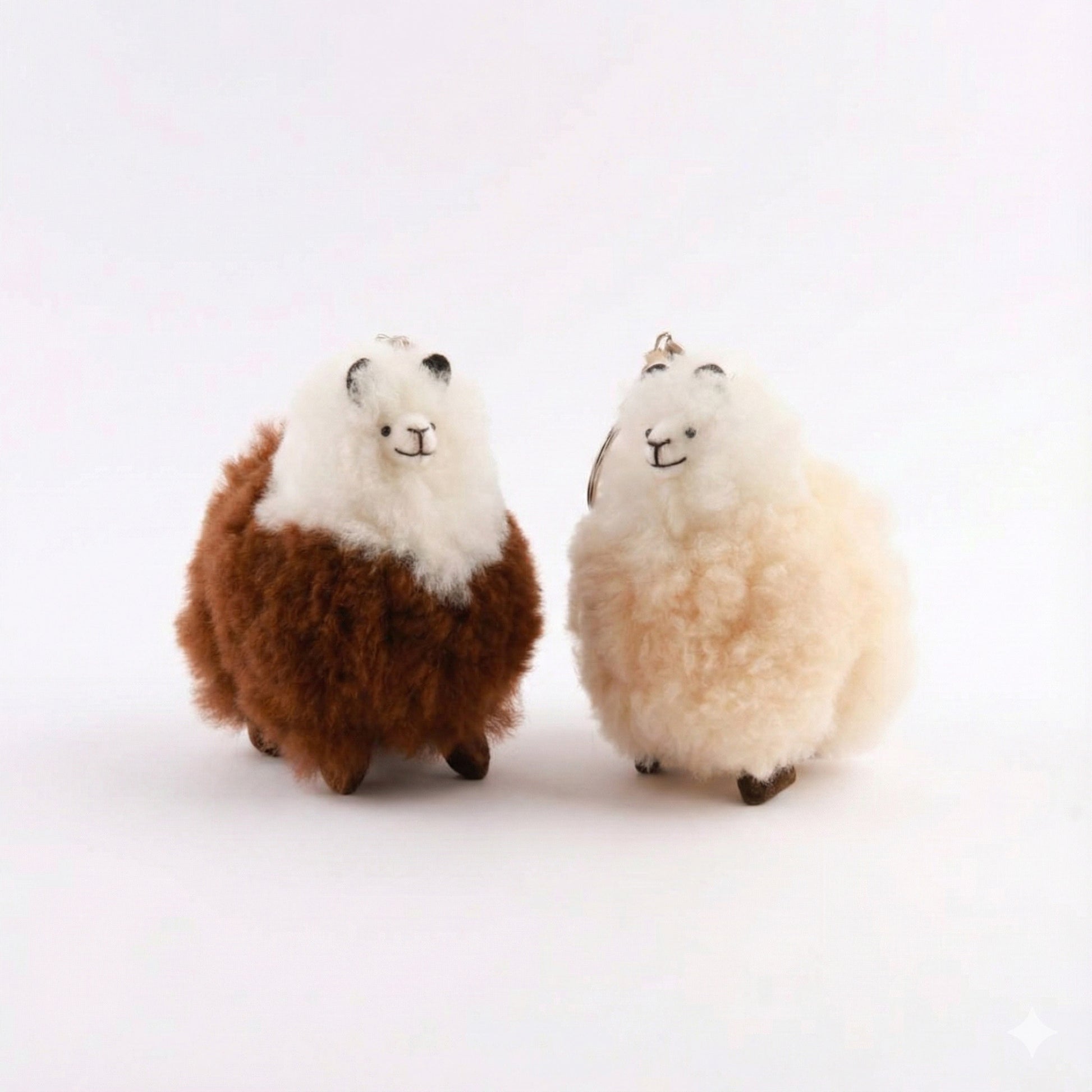 Two handmade alpaca fur keychains showing cappuccino two-tone and milk tea two-tone colors with cute embroidered faces