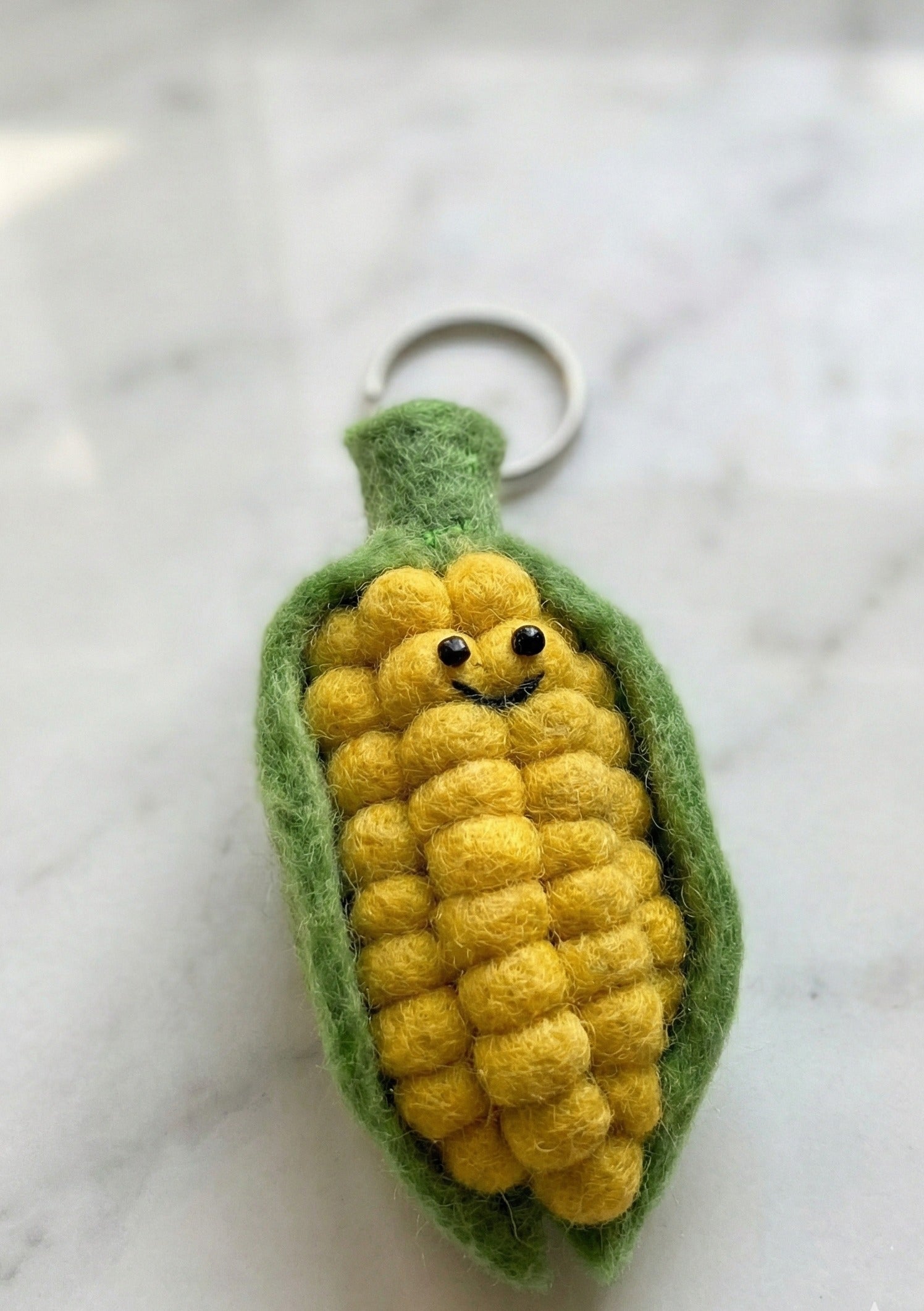 Cute corn keychain close-up - detailed textured kernels with smile