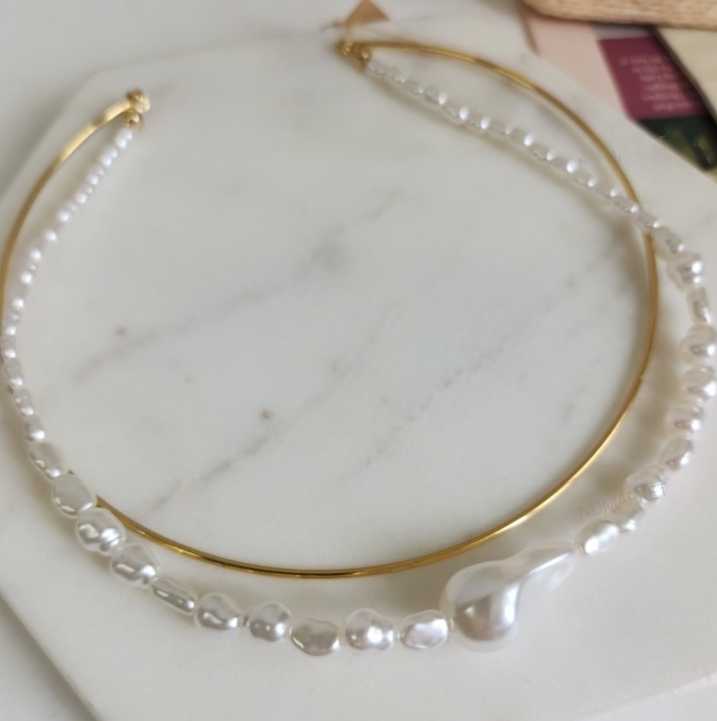 Close-up of gold brass wire choker with baroque pearl necklace detail