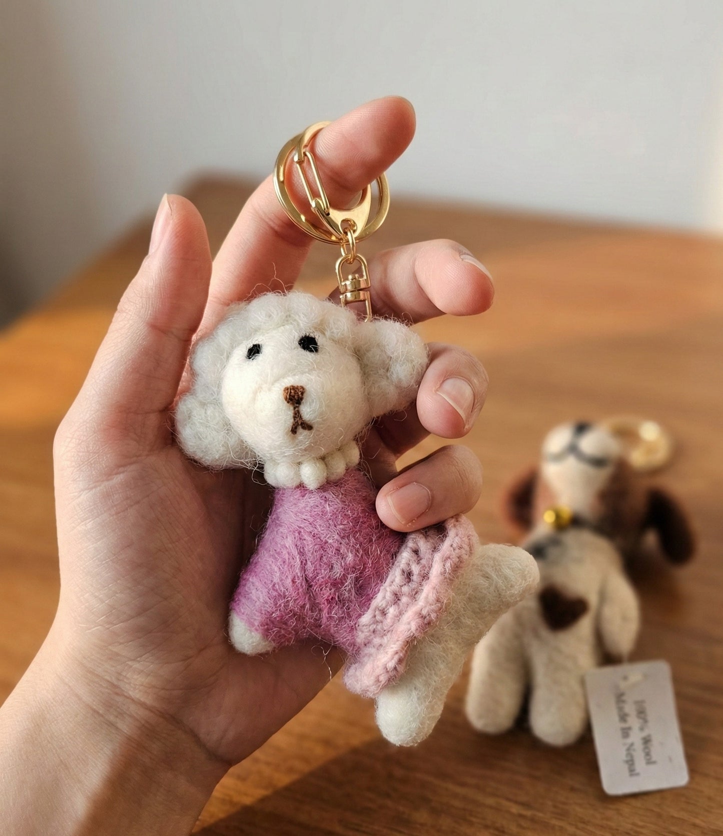 Cute needle felted white poodle bag charm held in hand showing size and detail