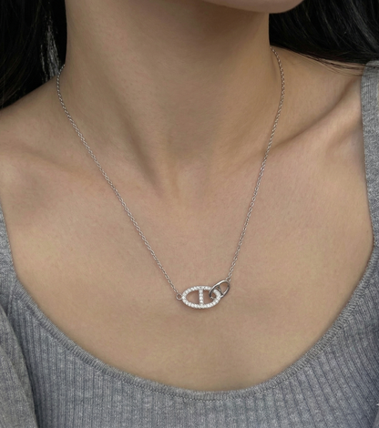Model wearing 925 sterling silver interlocking double ring necklace with a gray ribbed round-neck top, collarbone-length styling