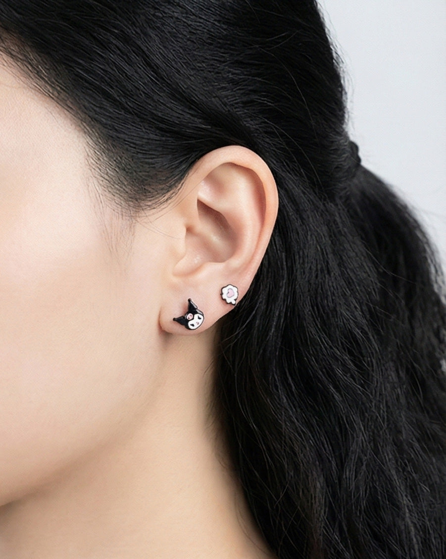 Woman wearing Kuromi and heart enamel stud earrings, side profile showing cute character design pair, 925 sterling silver posts hypoallergenic, Korean handmade Sanrio jewelry