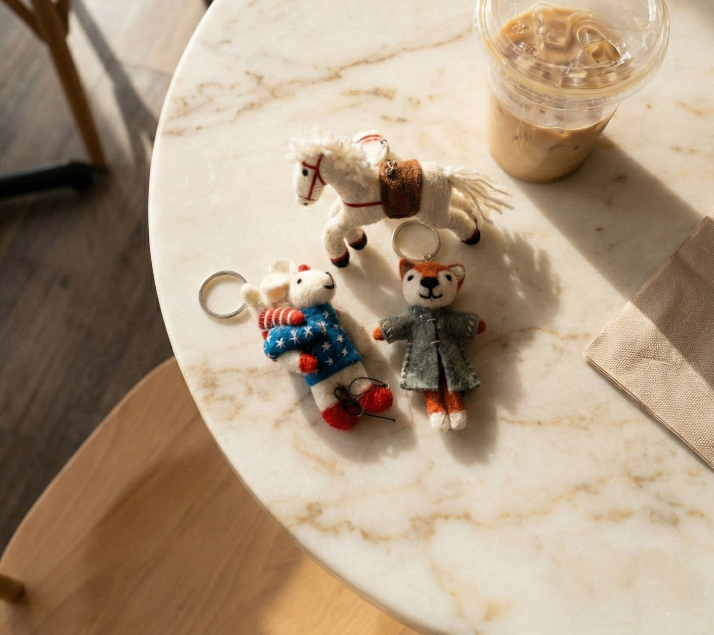 Woman holding camel leather hobo bag decorated with wool felt animal bag charms