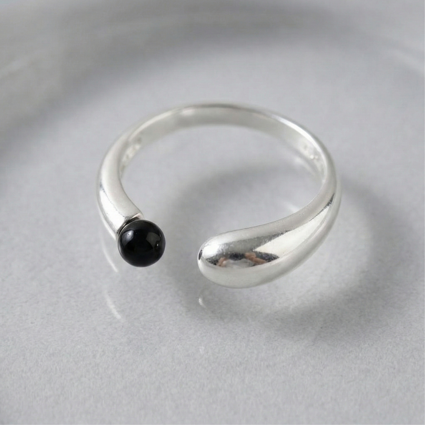 Close-up of 925 sterling silver single open ring with black onyx ball on gray surface — adjustable freesize statement ring