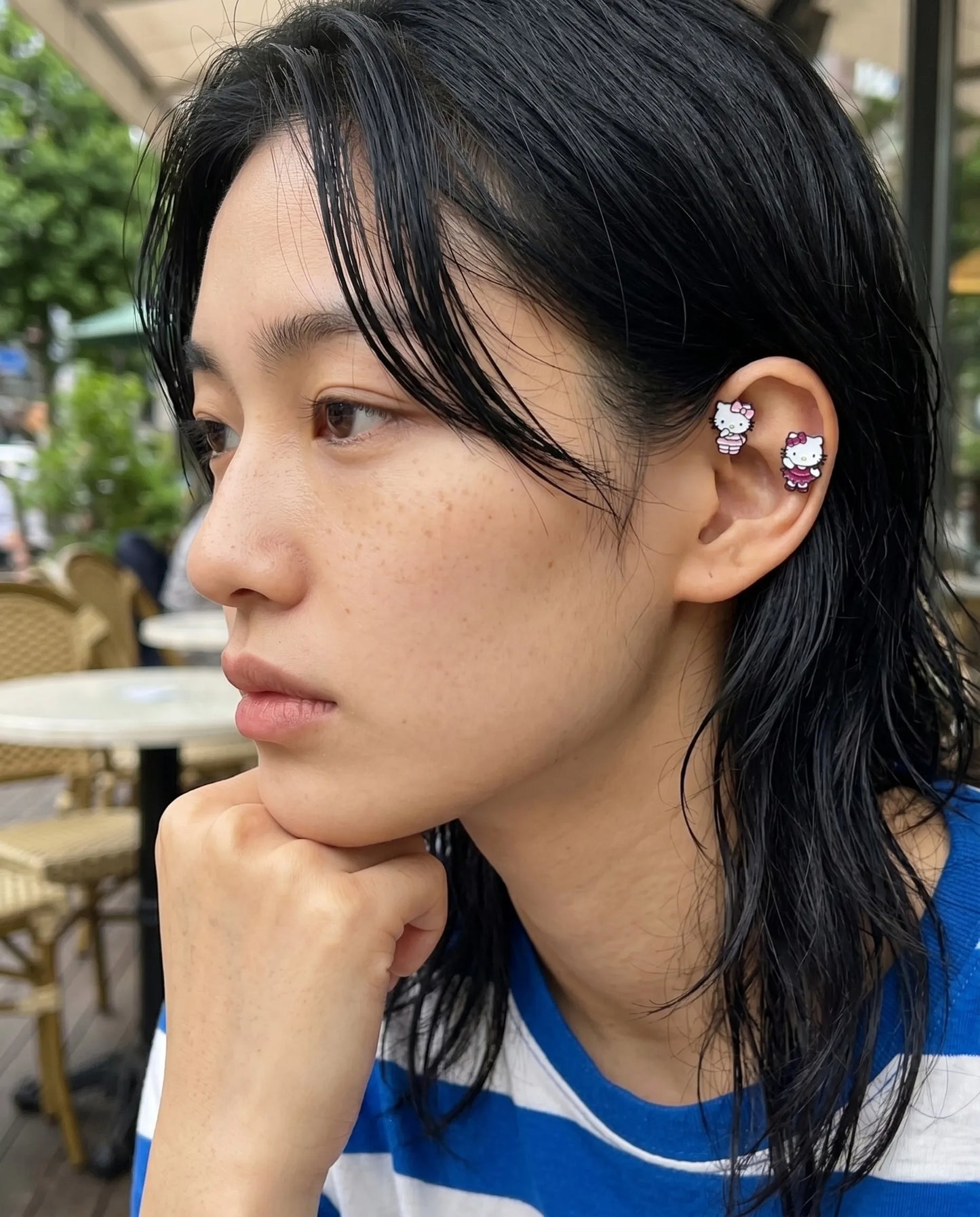 Effortless wet-hair look highlighting a bold Gen Z ear stack with a magenta ballet tutu Hello Kitty helix piercing
