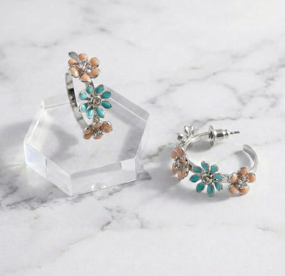 Close-up of mint garden enamel flower hoop earrings with titanium post on marble surface