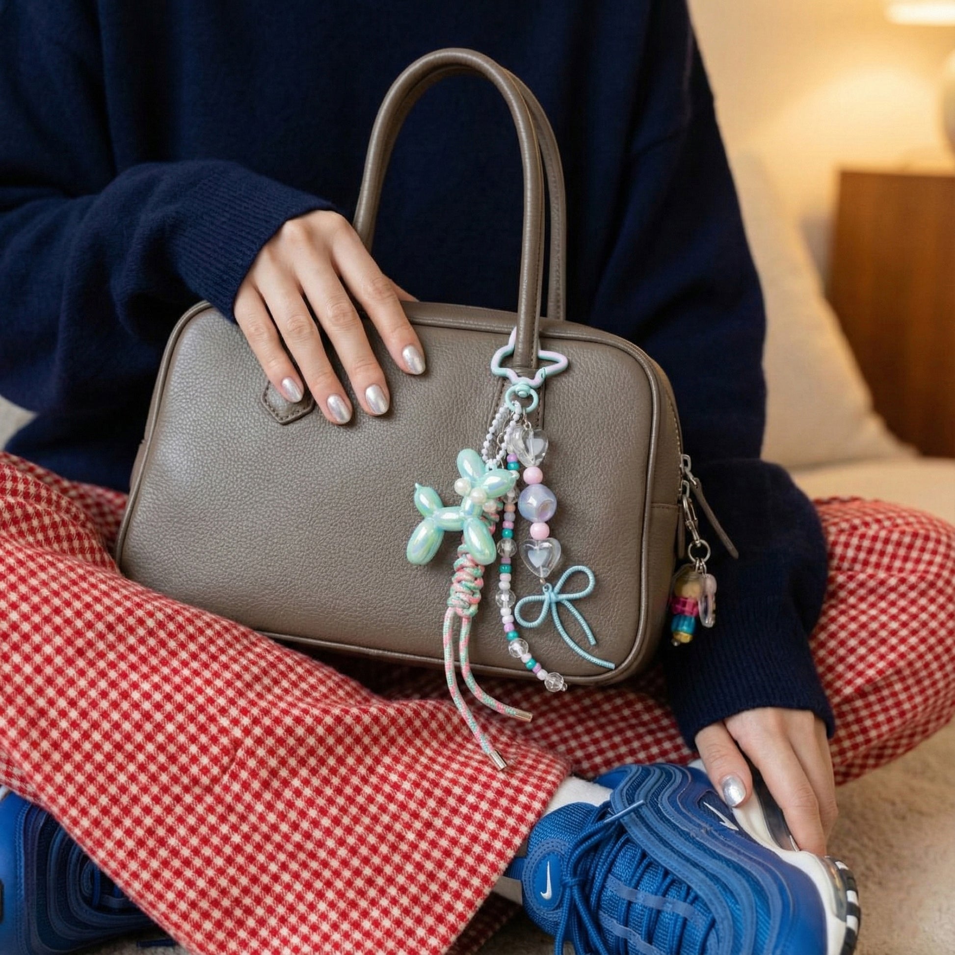 Aqua aurora balloon dog rope keychain with heart beads on neutral leather handbag