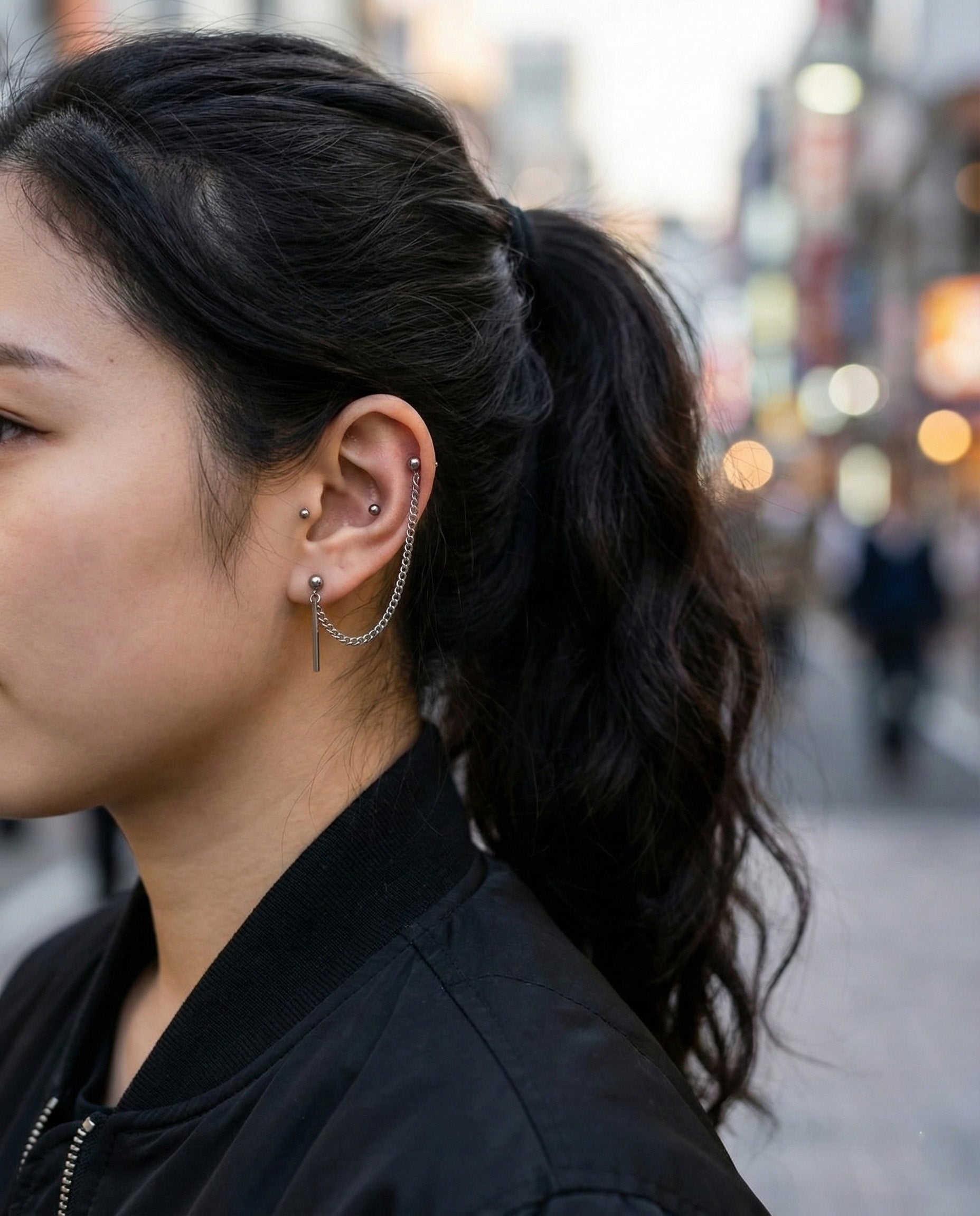 ide view of double barbell chain piercing with vertical stick drop on ear
