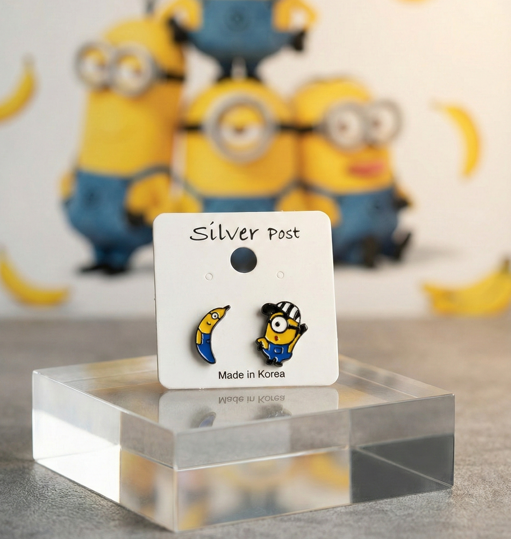 Minions asymmetrical earrings banana and blue overalls design on display card, handcrafted in Korea with 925 silver posts