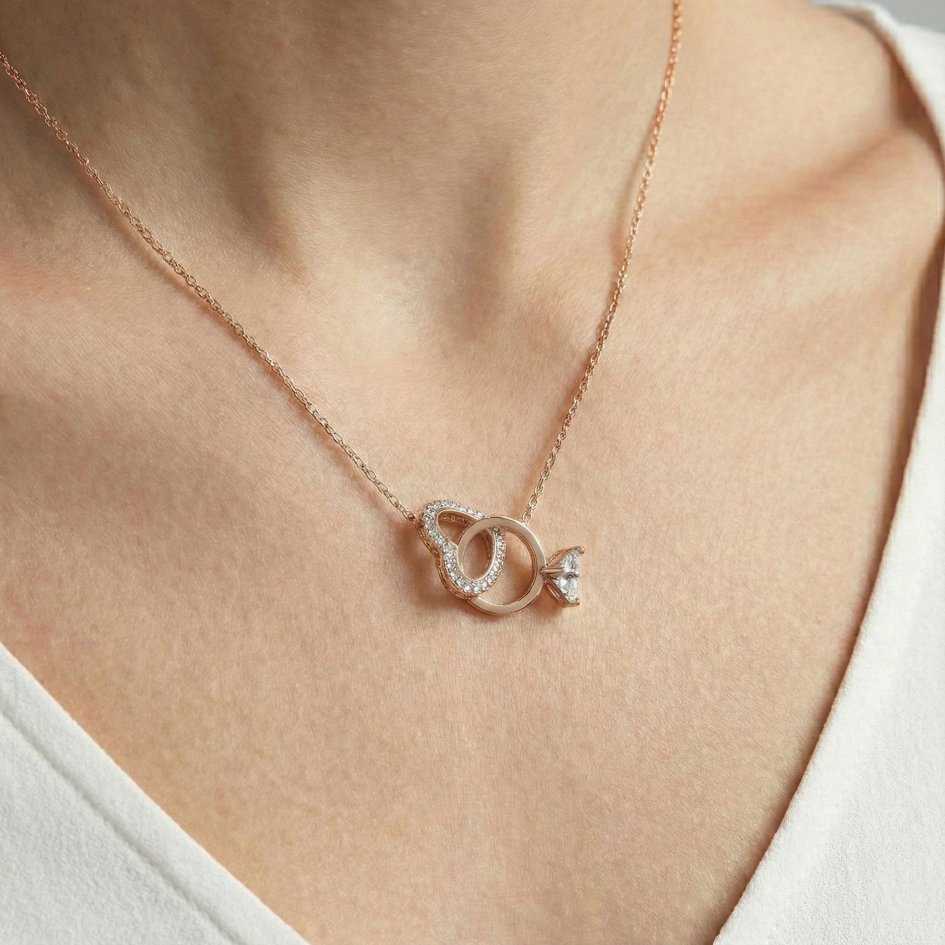 Rose gold pavé heart ring necklace close up on collarbone