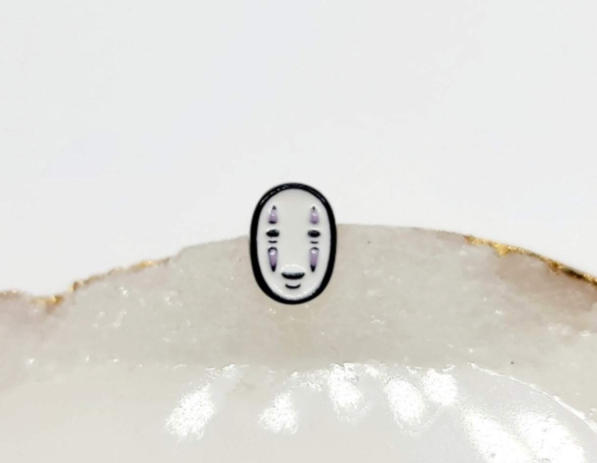 Close-up of No-Face classic face stud earring with white mask design on surgical steel post.