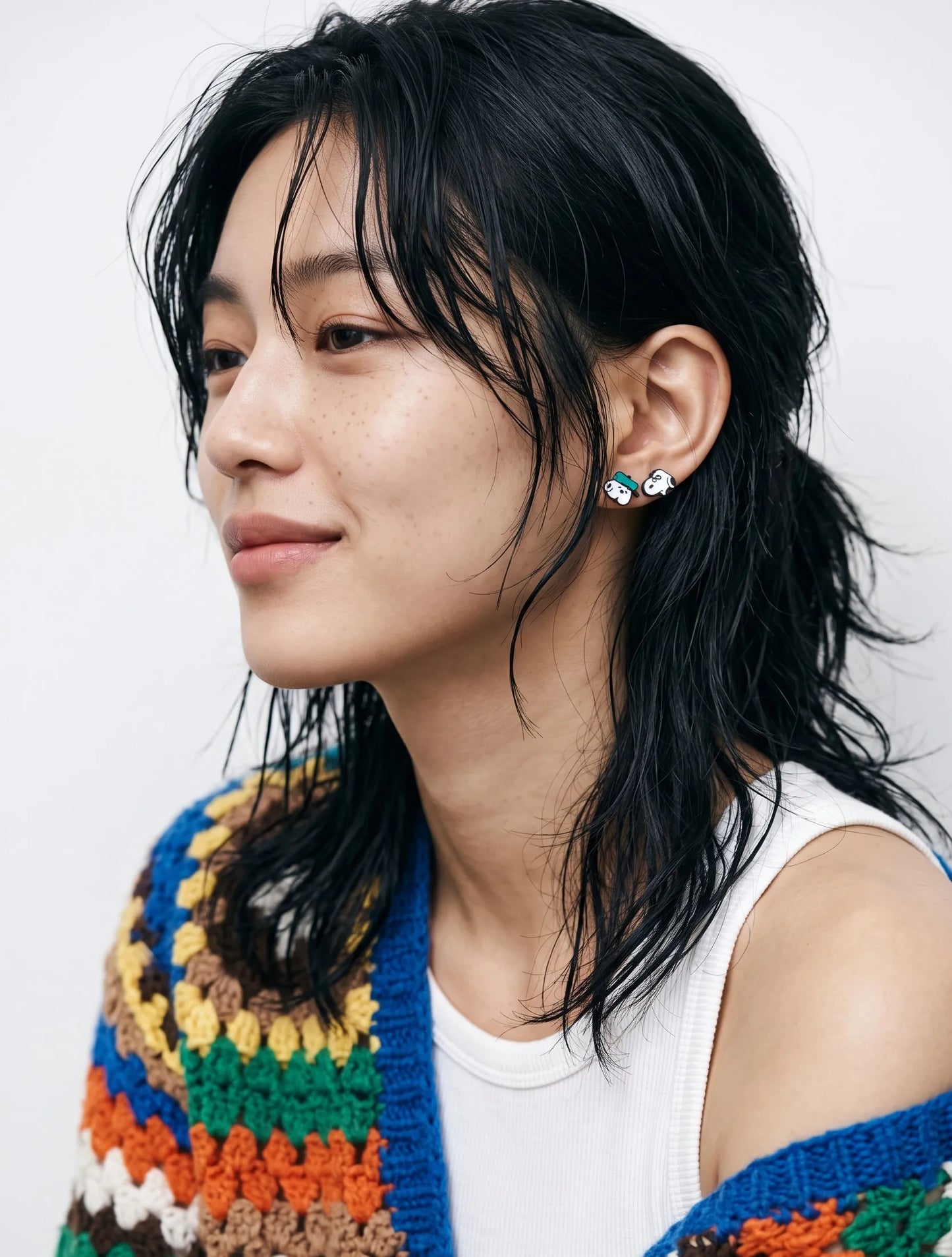 Layered hair styled with vintage cartoon stud earrings, curated ear piercing inspo