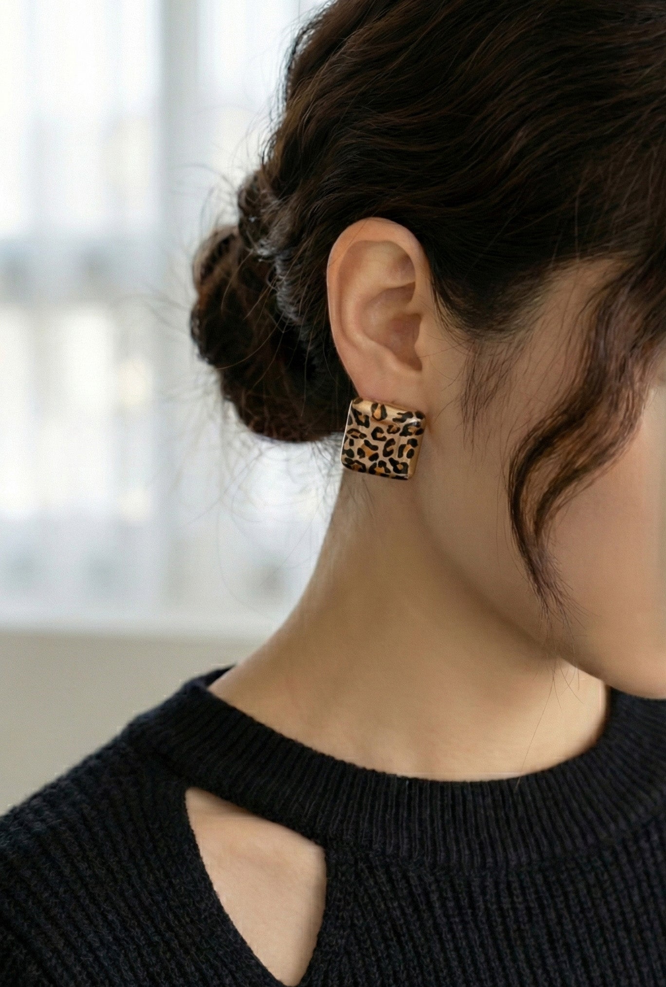  Leopard square earrings worn with black cutout knit sweater by window natural light