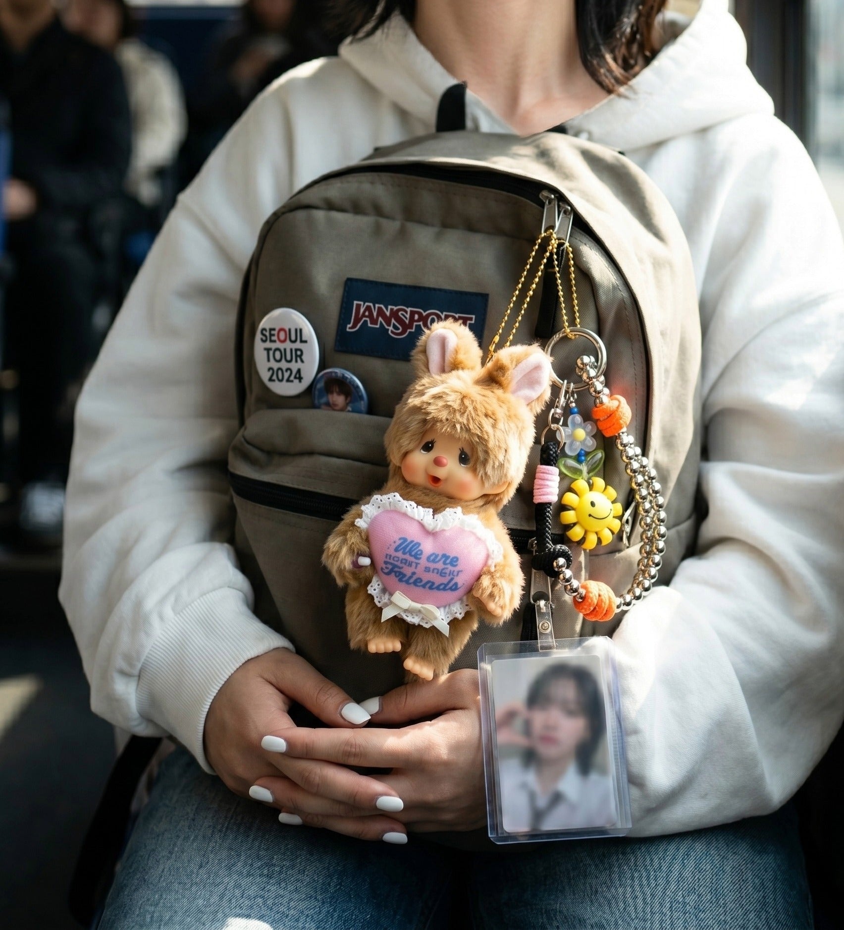K-pop fan bag charm aesthetic — Monchhichi sweet sugar friends pink heart bunny keychain on JanSport backpack, Seoul tour 2024 concertcore styling.