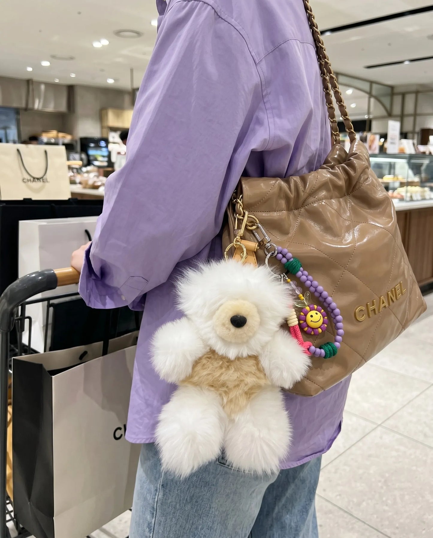 
Street modern bag charm stack inspo 8ttitto8 fluffy alpaca bear keychain with smile bead keychain on quilted designer bag, downtown girl K-style look.