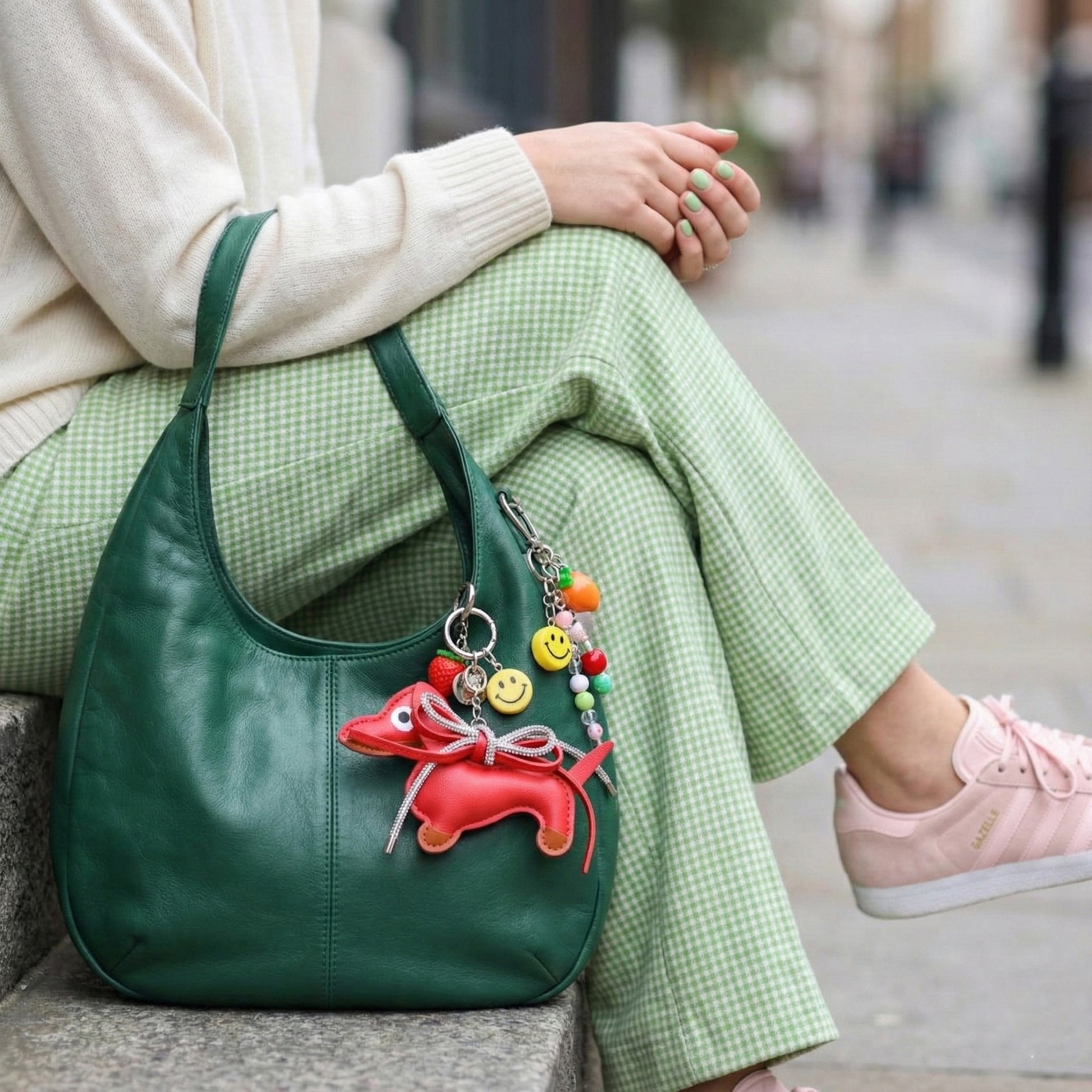 Red leather Dachshund keychain with crystal tail charm on green purse paired with gingham skirt and pink sneakers
