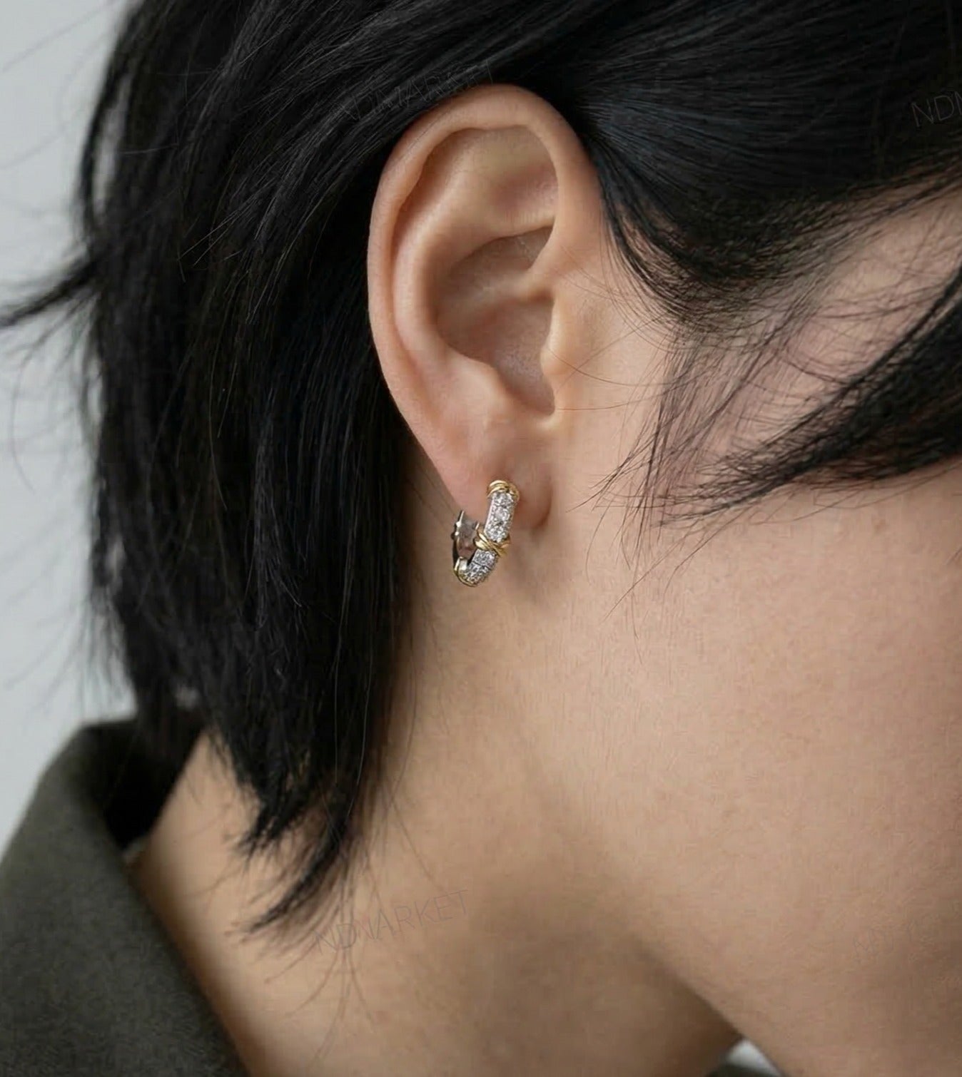 Close-up ear shot of two-tone pavé CZ hoop earrings, rear angle, olive jacket
