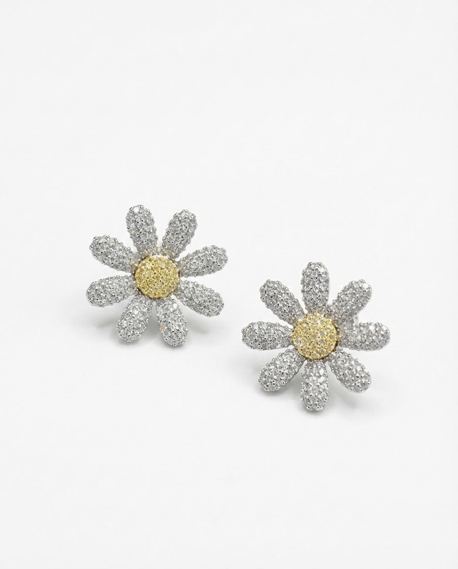 Sparkling pave daisy flower cubic zirconia stud earrings with yellow center on white background