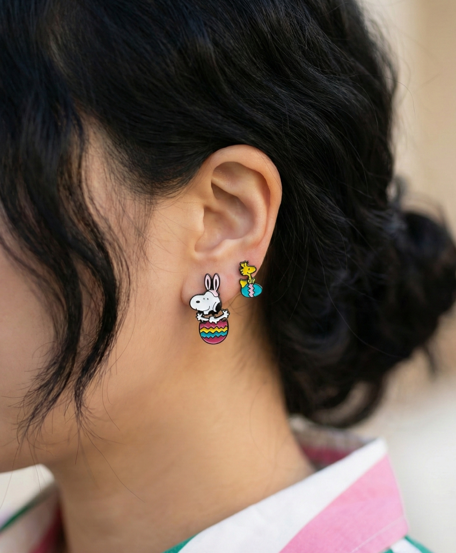 Model wearing asymmetrical Snoopy and Woodstock drop earrings with white collar shirt