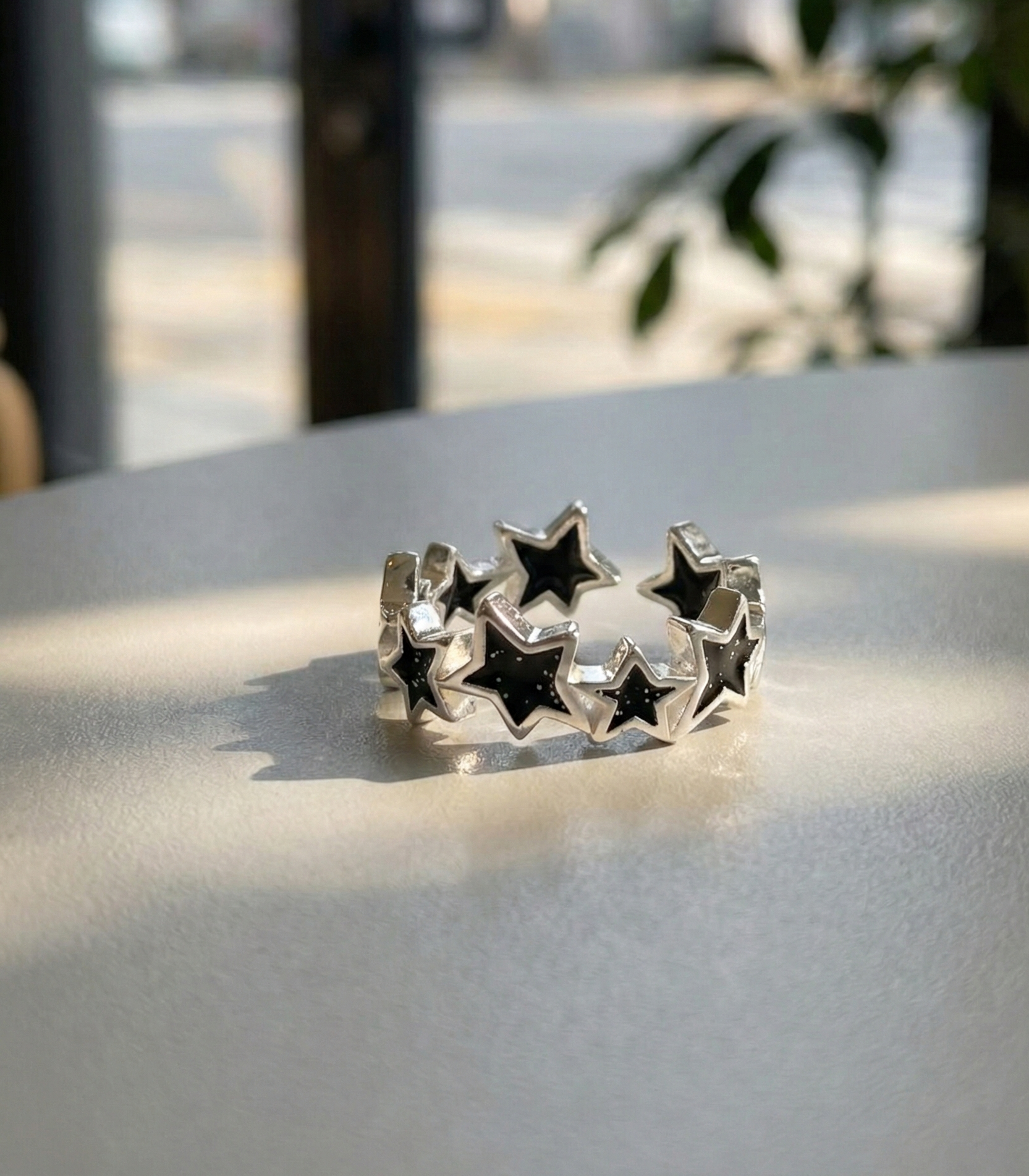Detailed shot of midnight black 925 silver adjustable star ring with sparkling glitter finish
