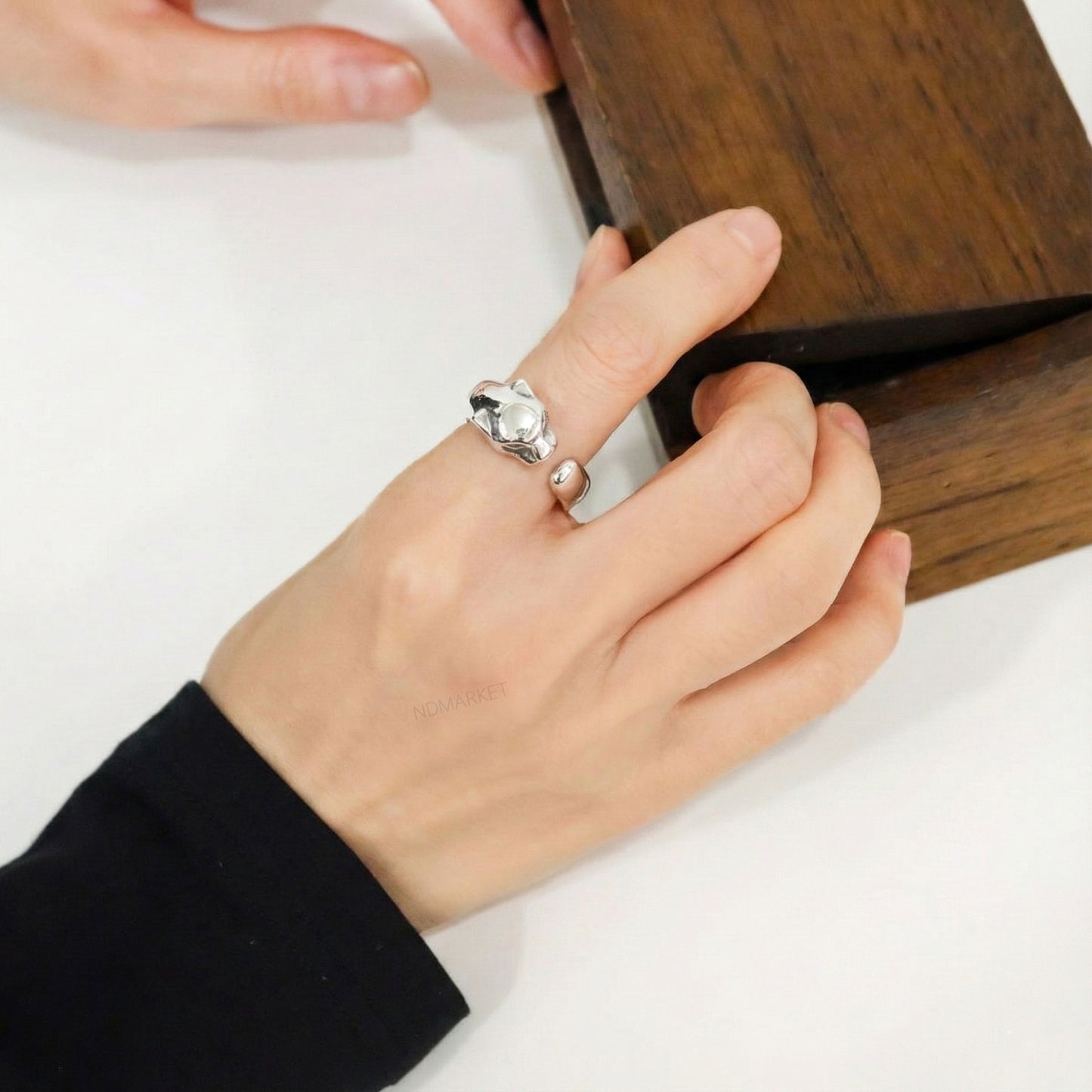  Hand wearing sterling silver panther ring on index finger layered with other silver rings