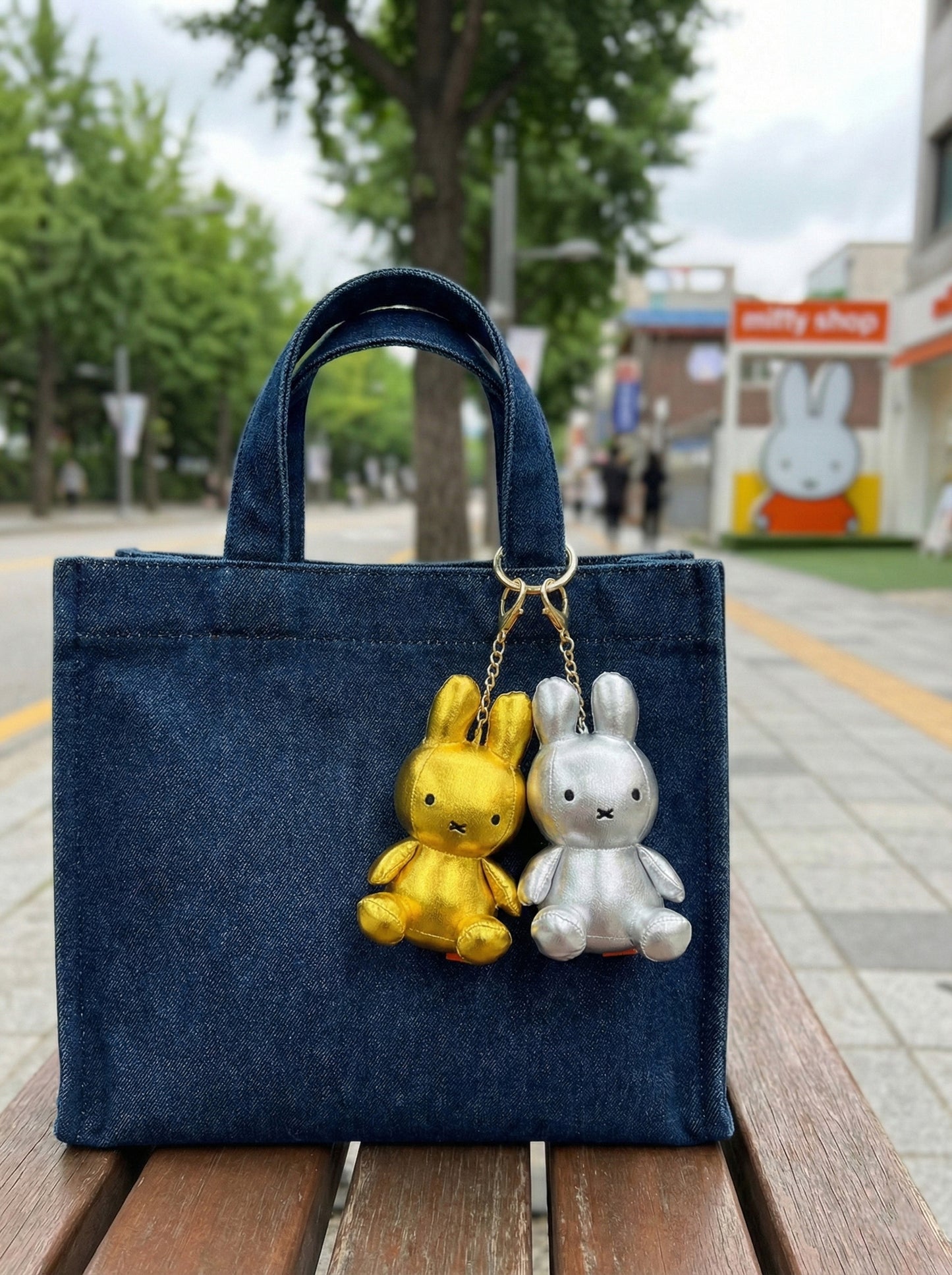 Gold and silver metallic Miffy keychains attached to denim tote bag - Y2K aesthetic