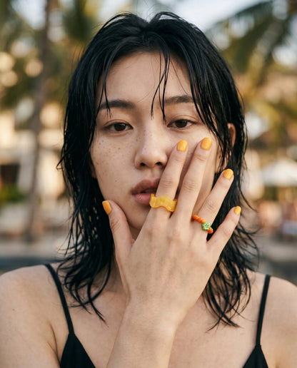 
K-style cool girl beach ring stack — yellow wavy chunky ring and green flower bead ring, Y2K summer vacation jewelry for layered ring inspo.