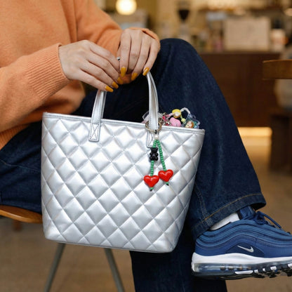 Red and green heart beaded keychain attached to silver quilted tote bag with cozy sweater styling