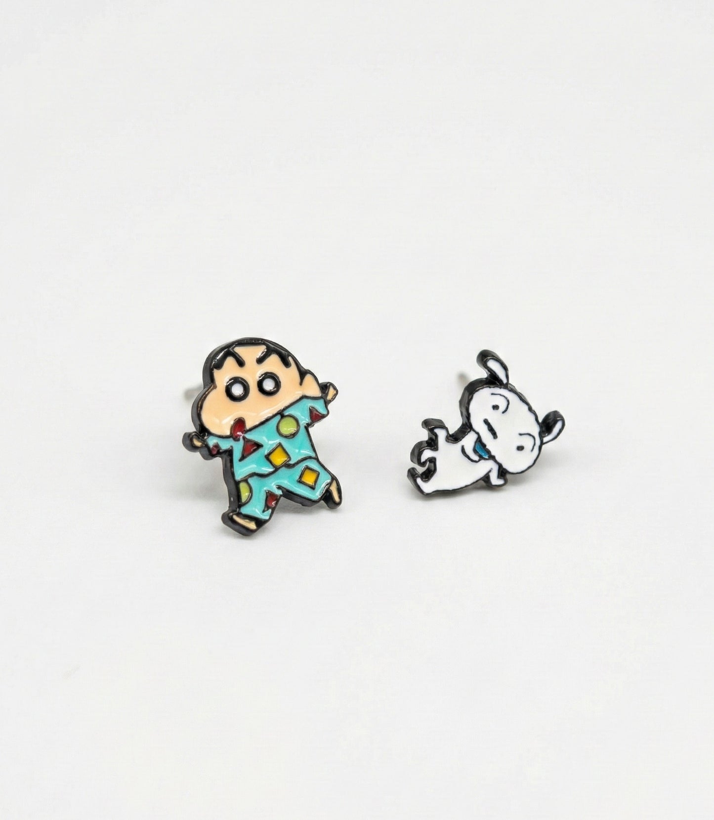  Shin-chan in geometric pattern pajamas and dancing Shiro enamel earrings displayed flat on white surface
