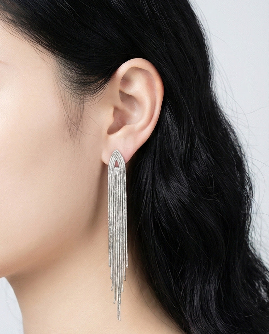 Side view of shoulder duster chain fringe earrings in silver, dramatic length statement accessory