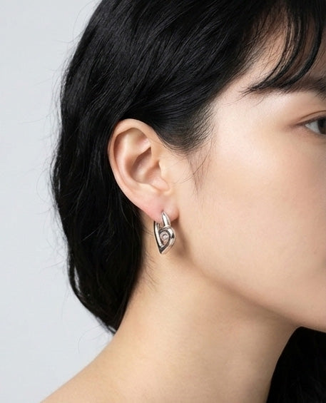 Front view of silver heart huggie earrings with sculptural twisted knot detail, hypoallergenic titanium post