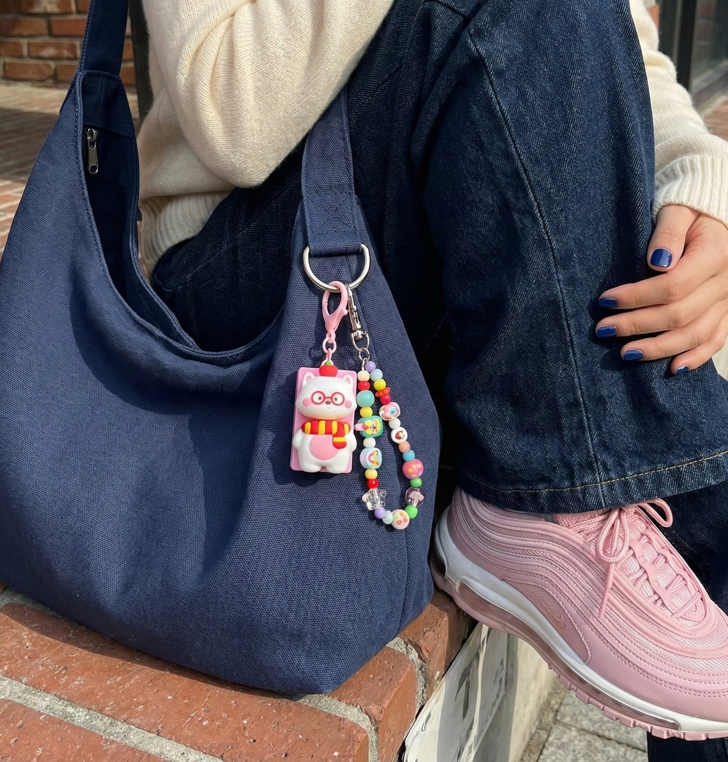 Navy blue bag with pink cat keycap keychain and colorful beaded chain accessory