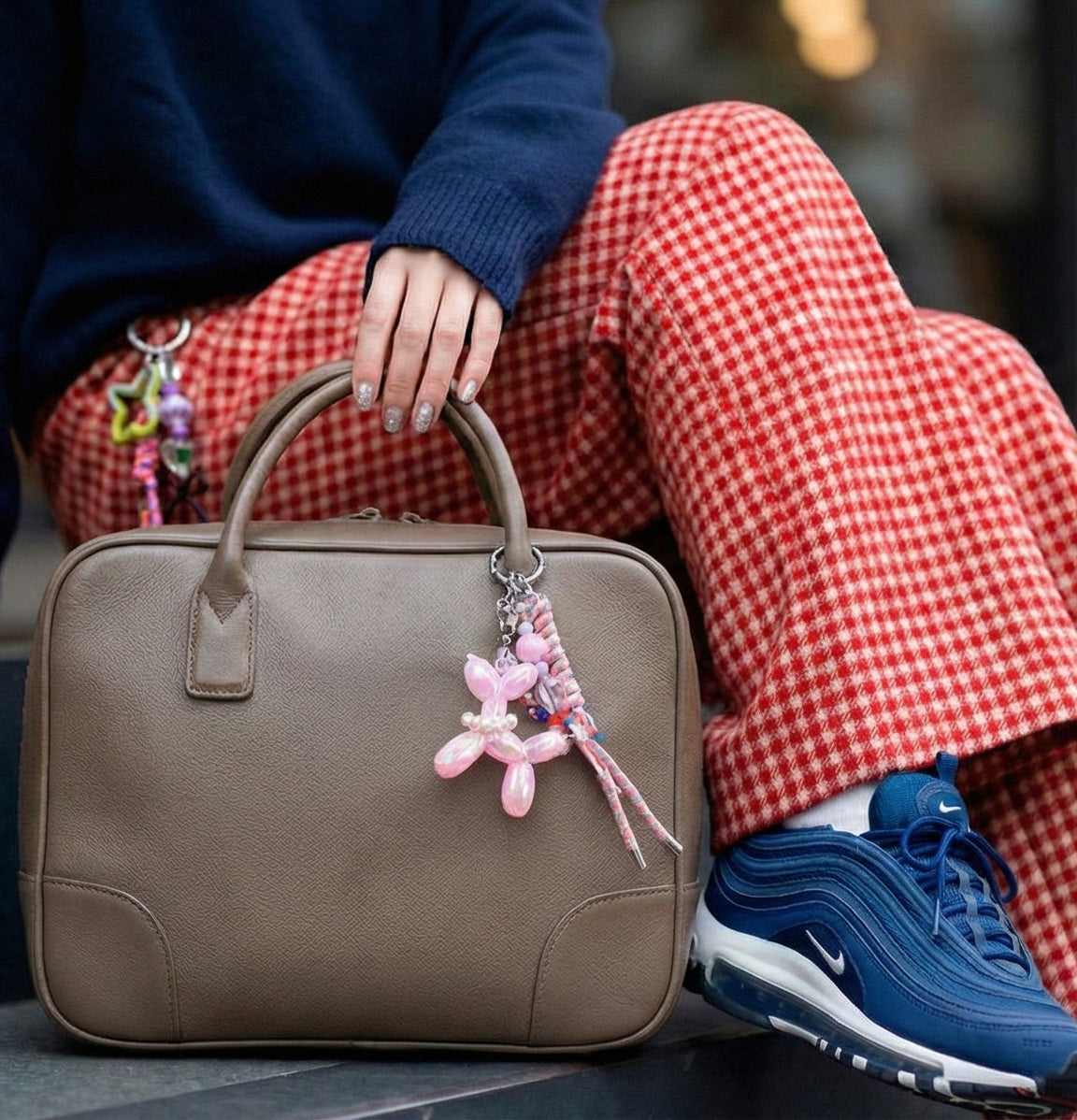 Lovely pink balloon dog bag charm with braided rope on beige leather bag