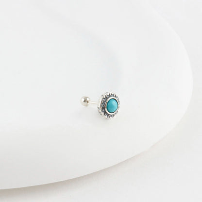 Turquoise sunburst barbell stud earring with vintage silver frame on white surface