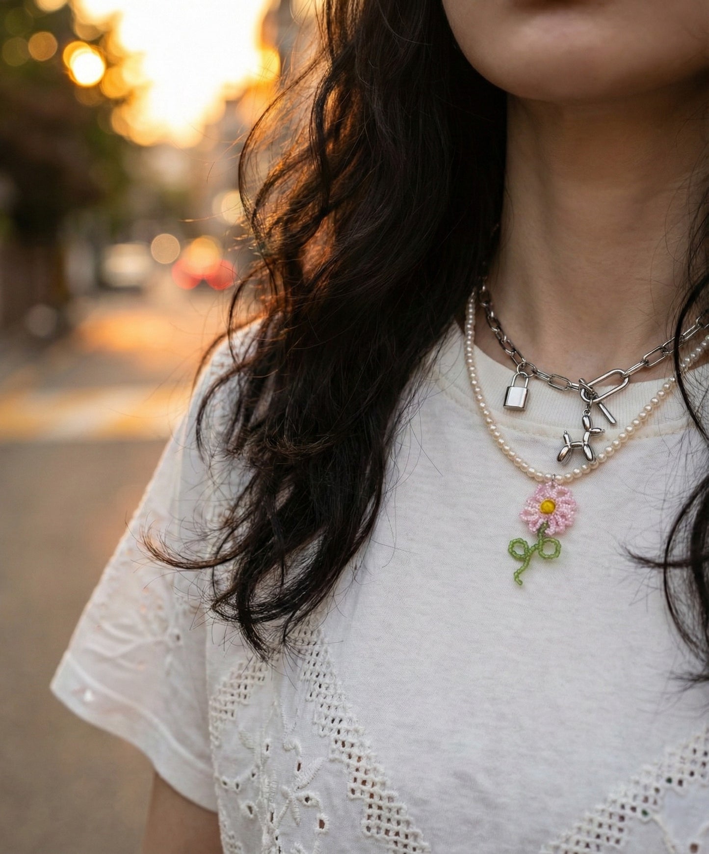 Layered necklace styling with pearl necklace and balloon dog chain necklace