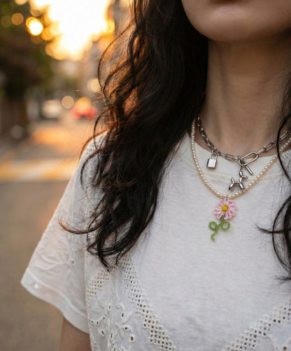 Layered necklace styling with pearl necklace and balloon dog chain necklace
