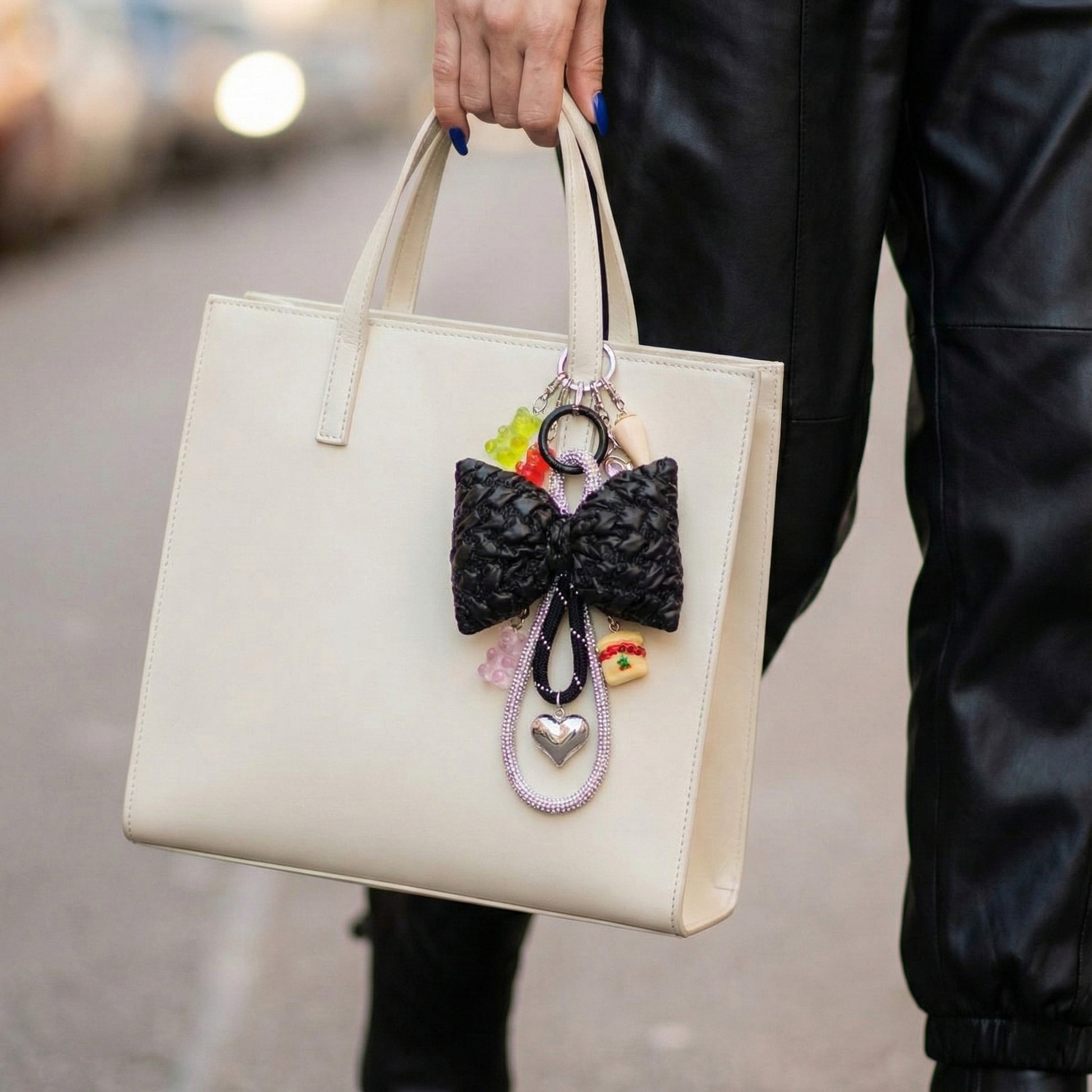 Handmade bow bag charm in black with colorful bead charms on white tote bag street style
