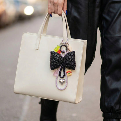 Handmade bow bag charm in black with colorful bead charms on white tote bag street style