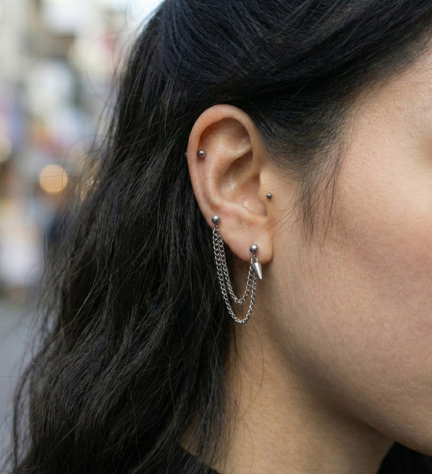 Grunge style ear styling with connected lobe and helix chain piercing 