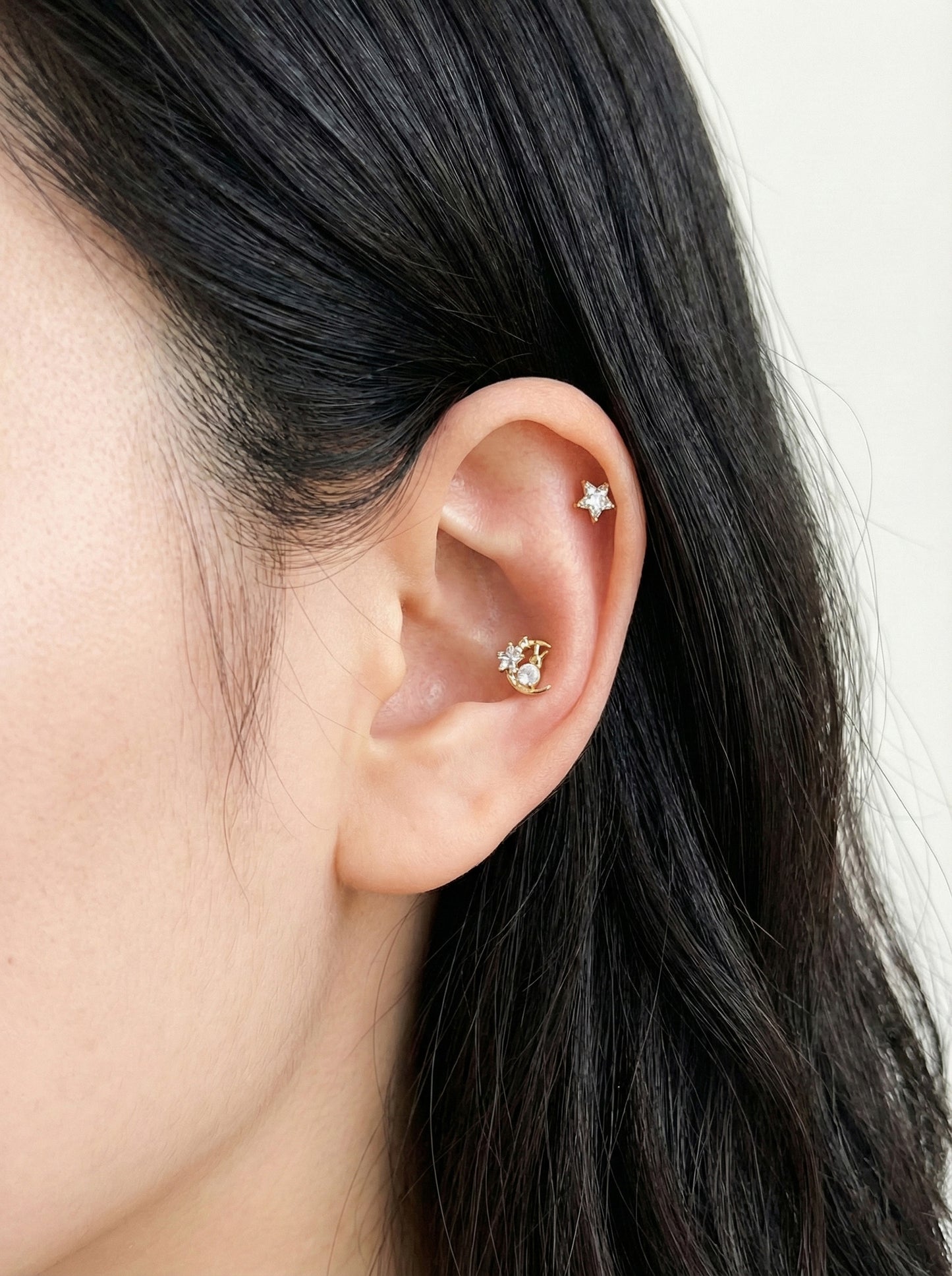 Gold plated crescent moon rabbit piercing in conch with star stud in helix for celestial ear curation