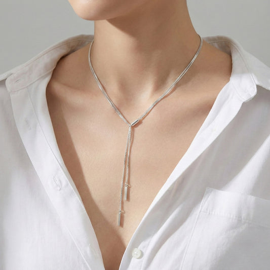 Minimal silver Y-drop necklace with double row box chain, worn with white shirt for clean everyday look