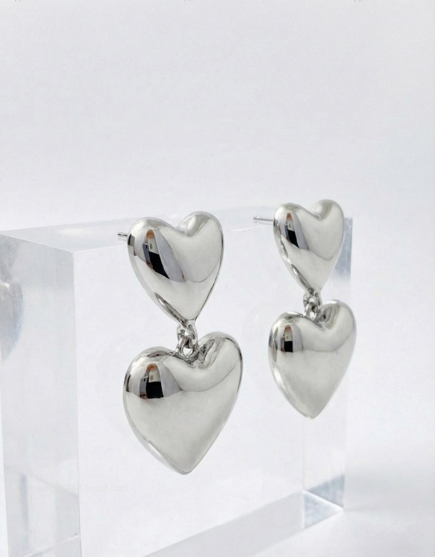 Silver puffed heart drop earrings on acrylic display - hypoallergenic titanium posts