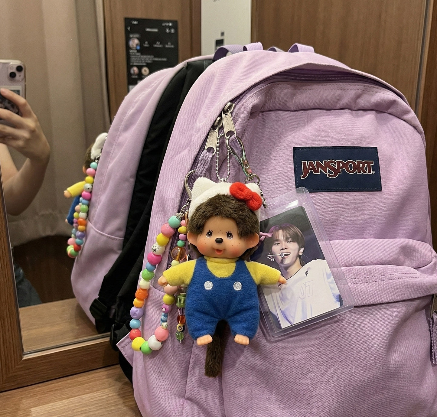 Purple Jansport backpack decorated with Monchhichi keychain and colorful beaded charm