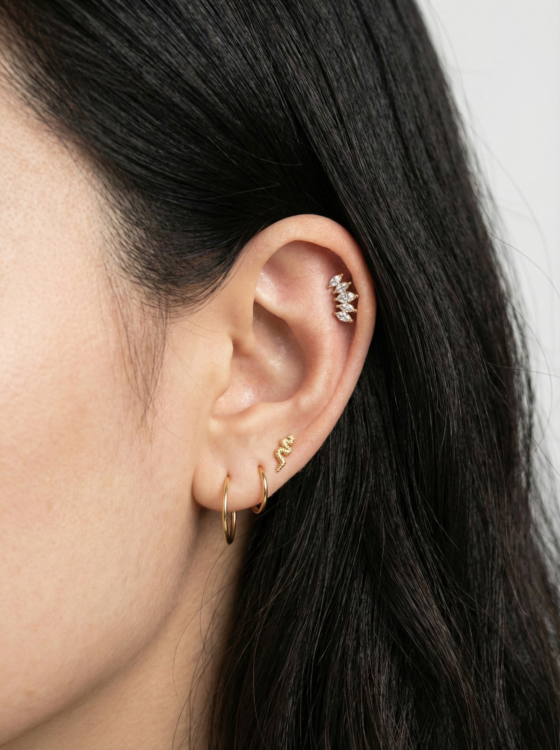 Elegant ear stack featuring wing marquise piercing on cartilage with gold hoops