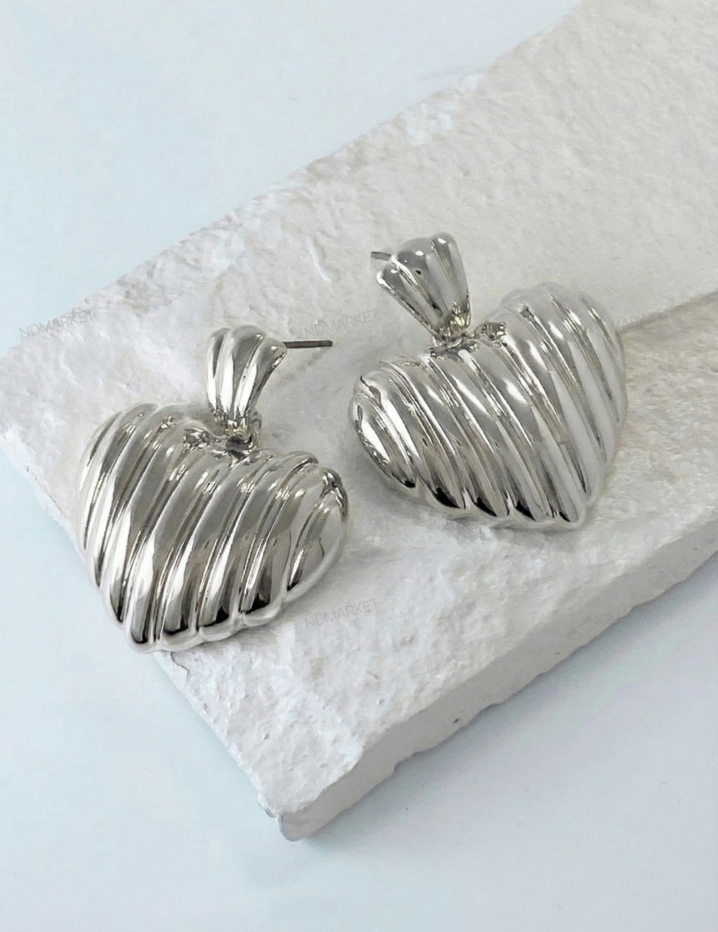 Silver chunky heart earrings with vertical pleated texture close-up