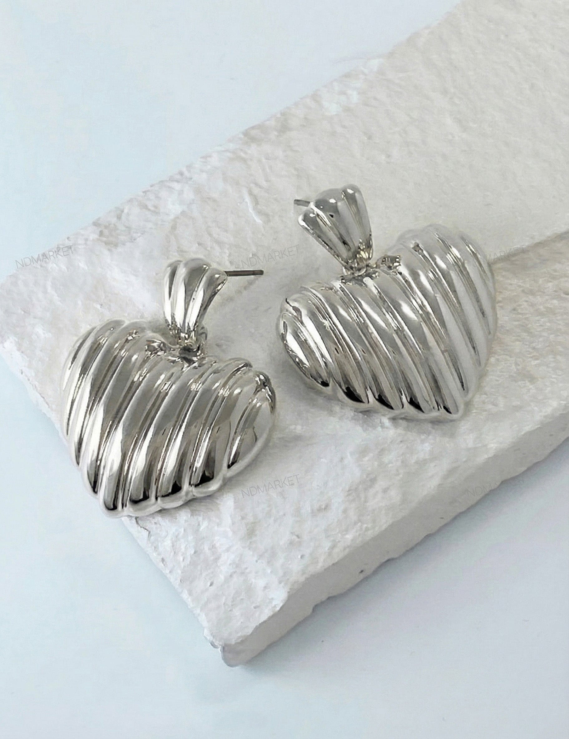 Silver chunky heart earrings with vertical pleated texture close-up
