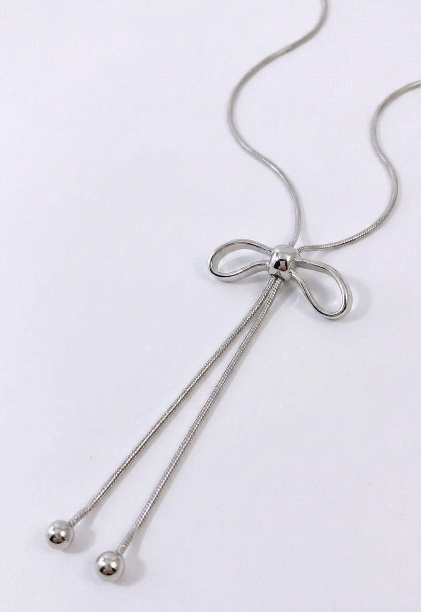 Silver ribbon bow Y-necklace detail - sleek snake chain with drop pendant