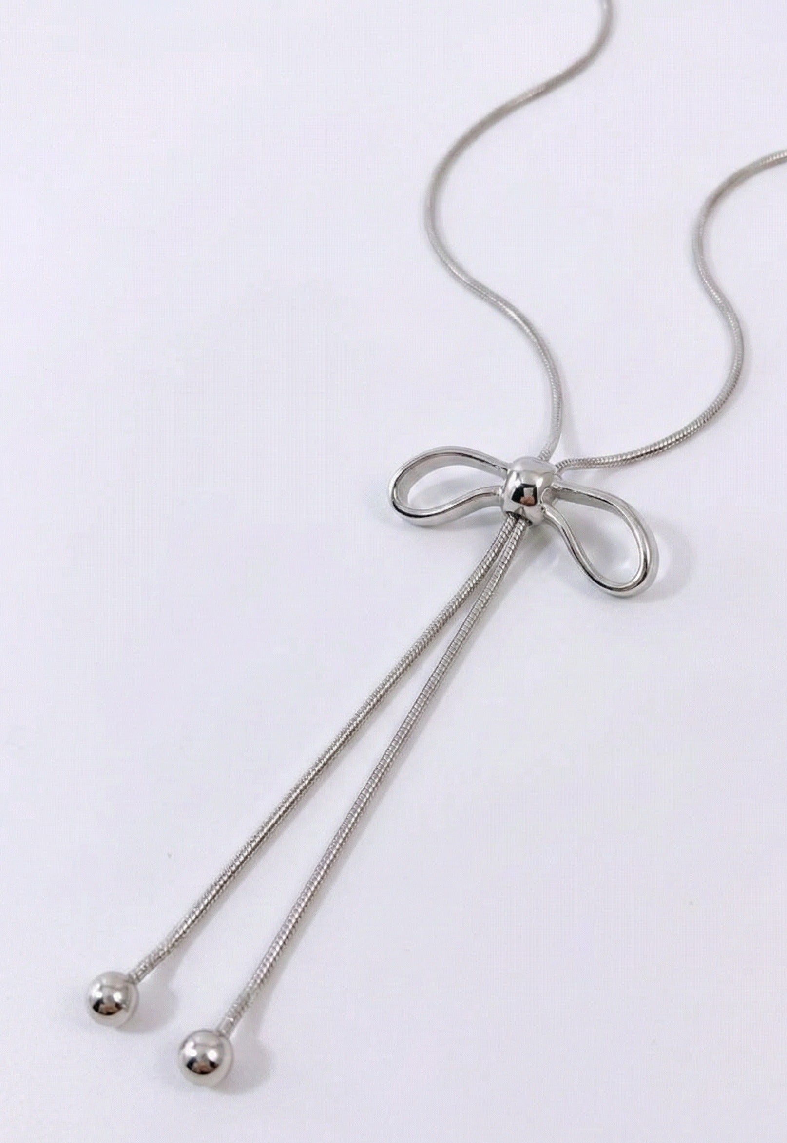 Silver ribbon bow Y-necklace detail - sleek snake chain with drop pendant