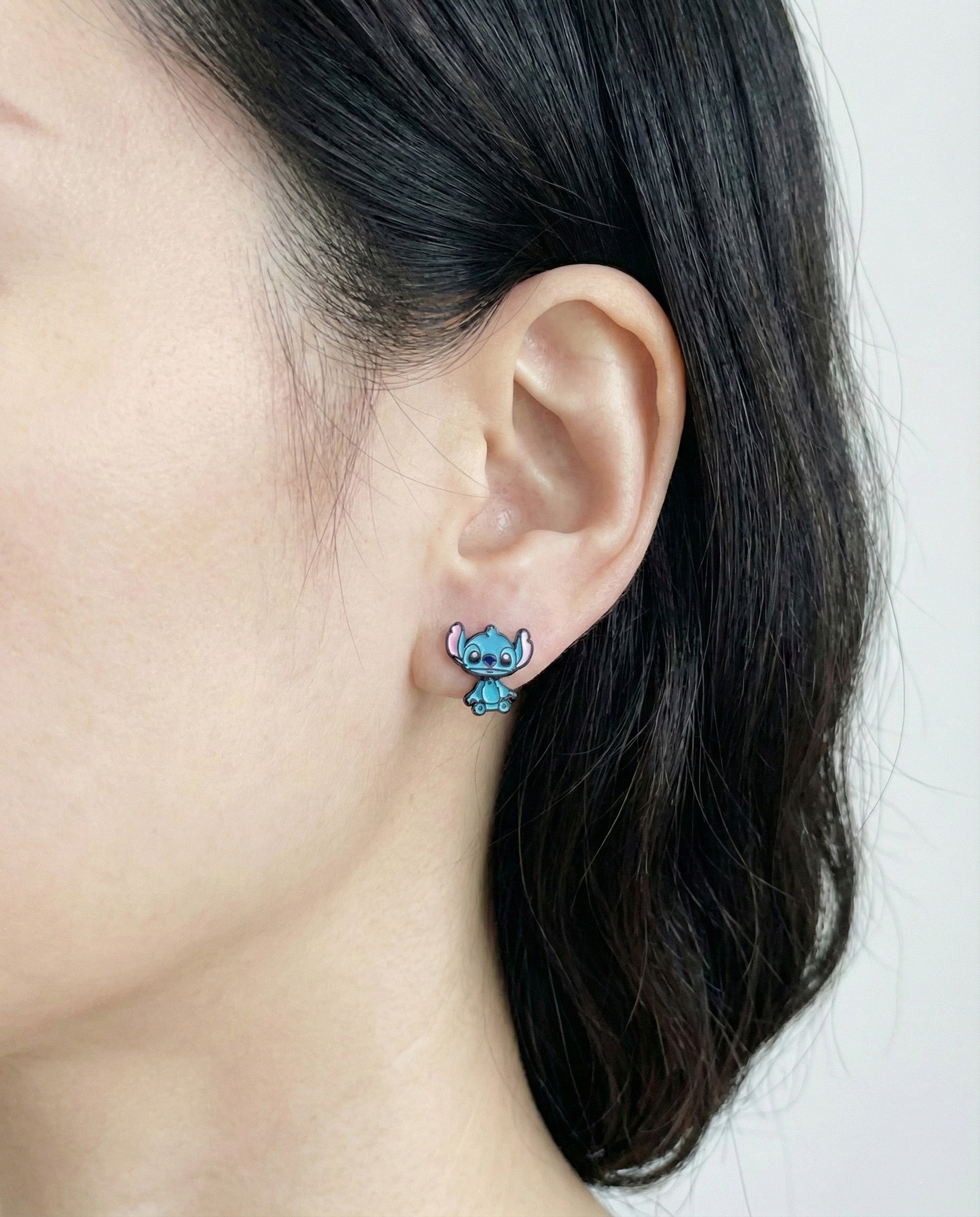 Woman wearing Stitch-inspired blue alien 3D ear jacket earrings showing front-back design with 925 silver posts