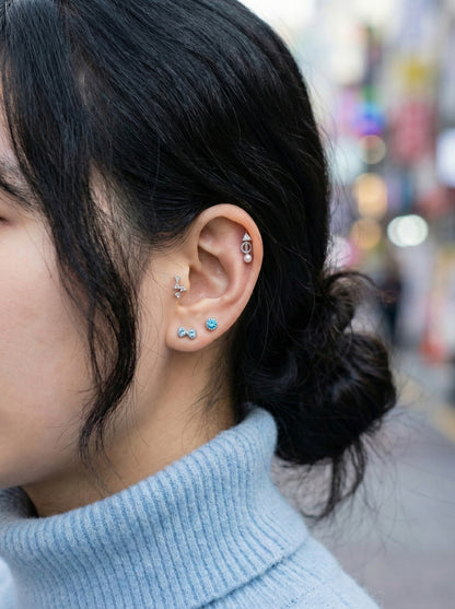 Side view of antique twisted rope pearl drop arrow helix piercing stacked with minimalist studs on ear